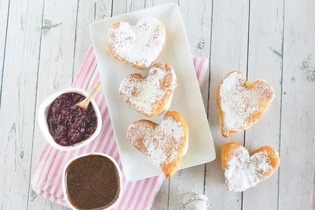 Valentines Day breakfast idea of heart beignets with chocolate sauce at thebensonstreet.com_ scaled