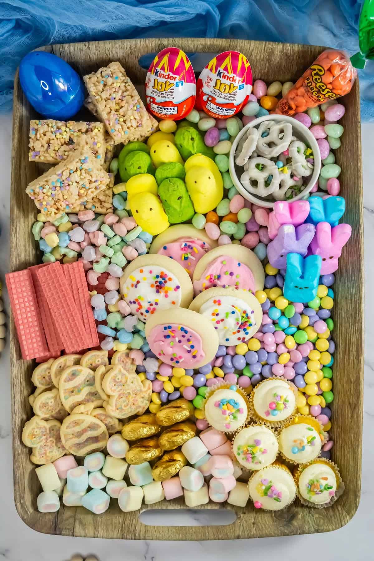 A colourful Easter dessert board filled with pastel sweets, chocolates, and festive treats.