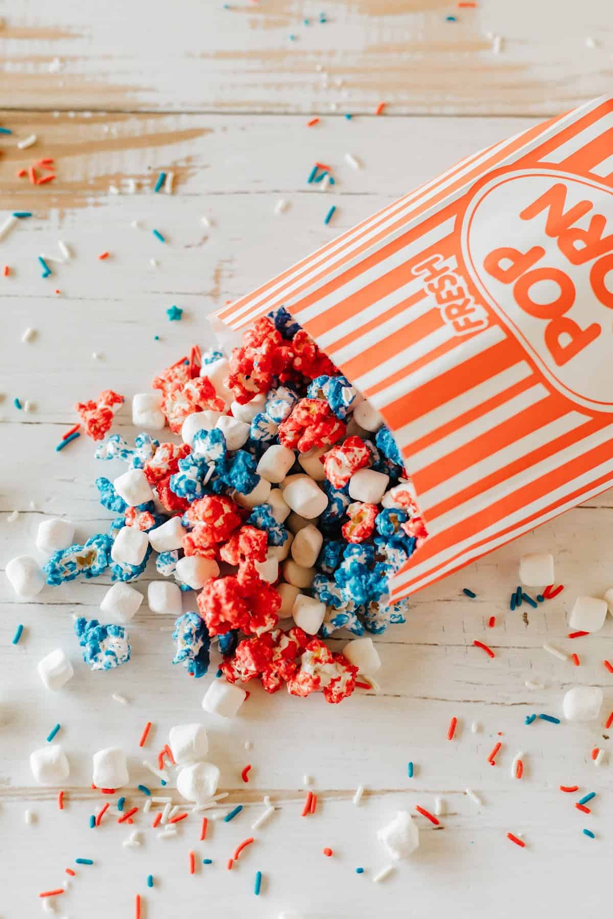 Patriotic popcorn recipe featuring red, white, and blue popcorn with marshmallows &ndash; perfect for parties and celebrations.