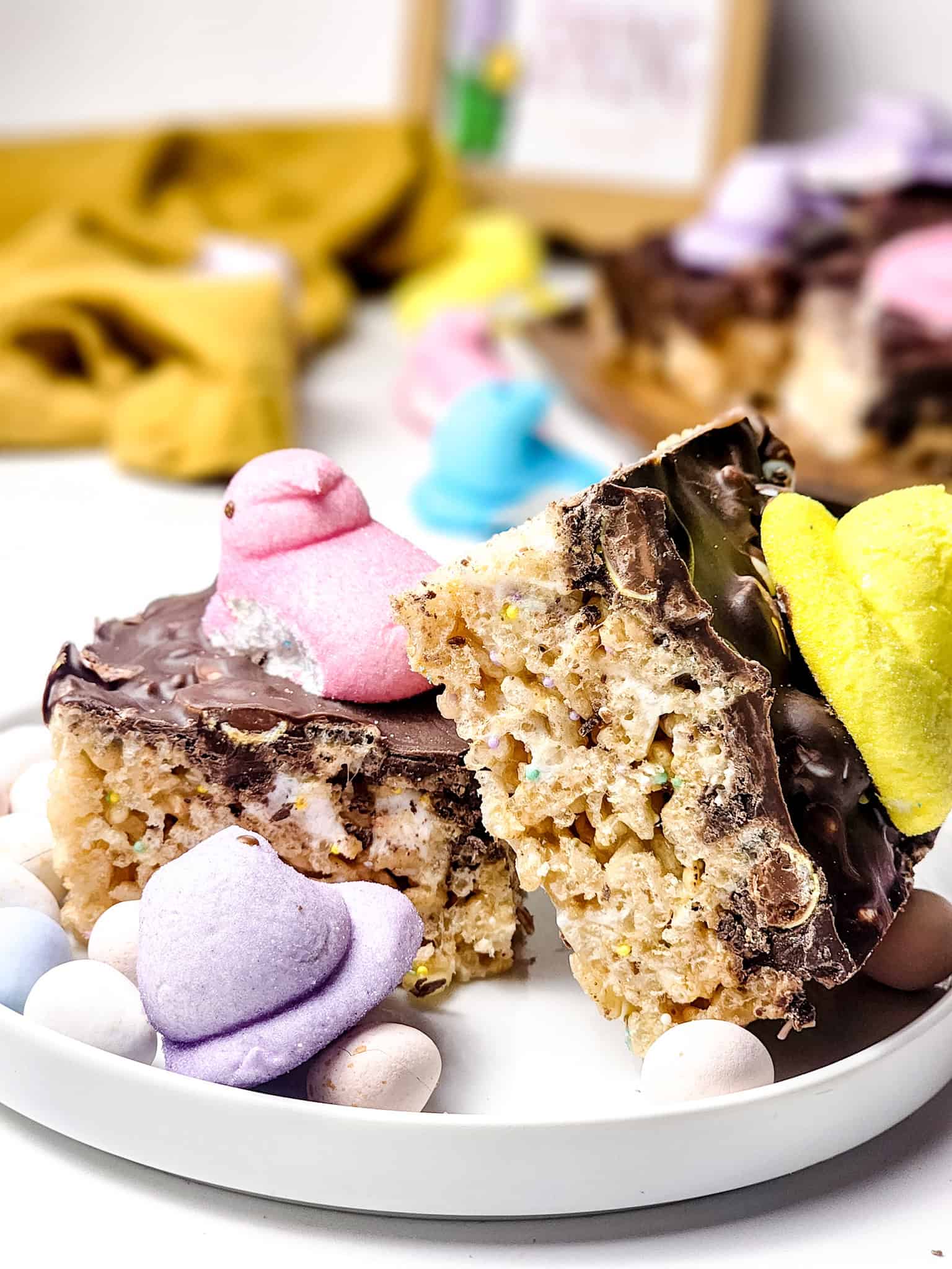 Festive Easter Rice Krispie Treats topped with Peeps and chocolate drizzle.